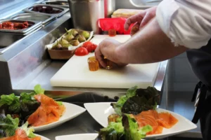 Préparation d'une entrée avec des produits frais et fait maison, saumon fumé maison et foie gras maison avec la gelée du restaurant gastronomique traditionnel L'Art de Vivre à Moosch dans le Haut-Rhin en Alsace